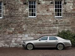 Bentley de profil fond ecran berline luxe gris metallise chateau murs brique biussons terre glaise fenetres style ancien