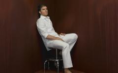 Dexter fond ecran portrait acteur dexter plan large chemise pantalon blancs assis tabouret image decor pourpre sang