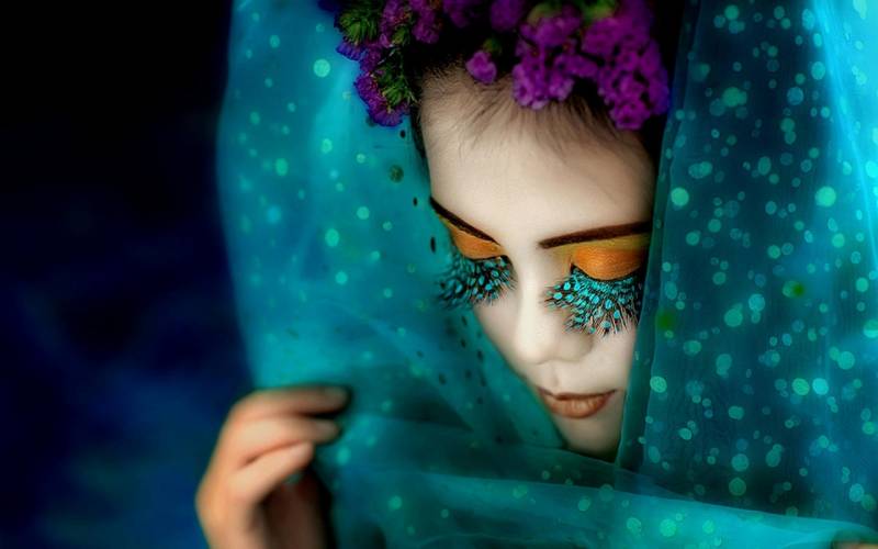 Fond écran artiste danseuse voile turquoise cils colles plumes paon couronne fleurs violettes maquillage art image fond bleu