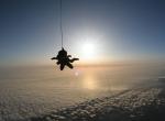 Fond ecran sport extreme parachutiste suspendu par cable chute libre au dessus nuages rayons soleil ombre image nature