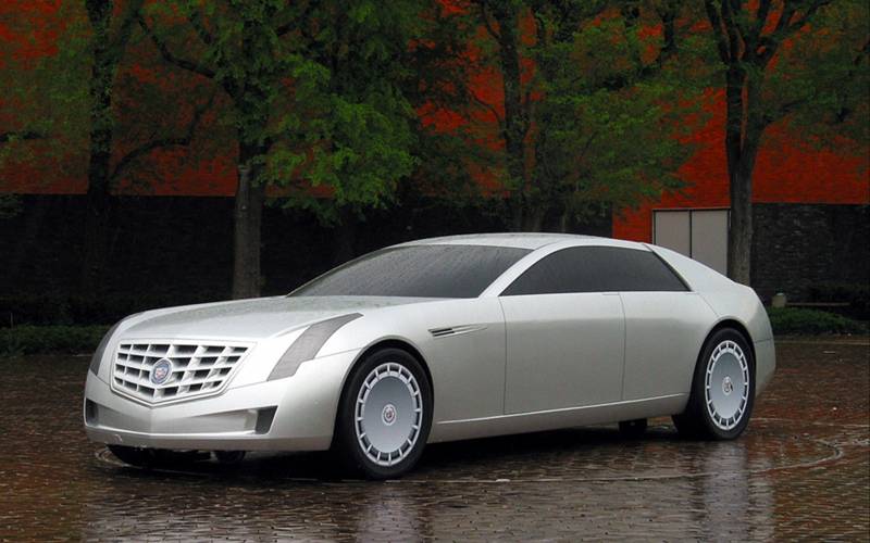 Fond ecran voiture berline beige gentes aluminium sous la pluie arbres place dalles rouges
